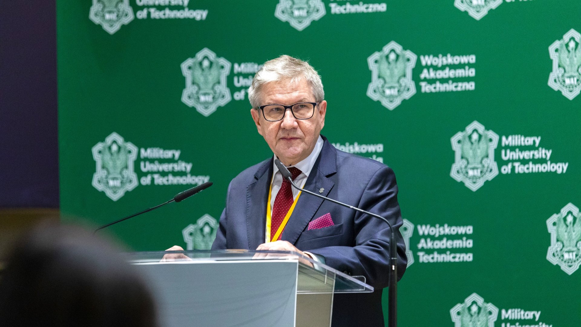 Fot. 1. Profesor Jerzy Jackowski stojący przy mównicy przodem do zgromadzonych gości.