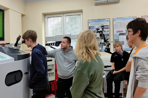 Fot. 3. Pracownik Wydziału w Sali laboratoryjnej prezentuje zastosowanie lasera przy użyciu mikroskopu.