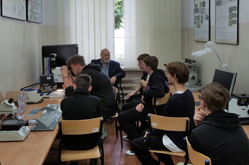 Fot. 4. dr inż. Wojciech Napadłek i studenci, siedząc - prowadzą dyskusję na temat technologii laserowych w przemyśle.