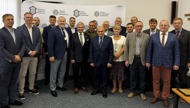Grupa osób stojąca przodem do fotografa, w tle baner WIM WAT