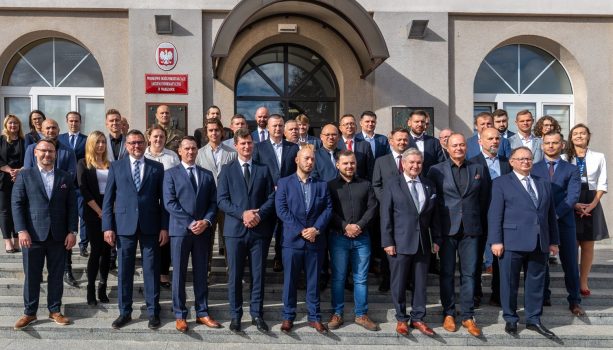 Uczestnicy, Władze WIM i WAT, prowadzący, dyrekcja PERN stoją tyłem do budynku pozując do zdjęcia.
