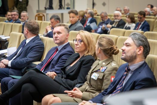 Przedstawiciele organizatorów na Konferencji. Siedzą w fotelach w sali klubu WAT, przodem do prowadzących i ekranu.