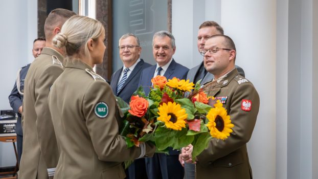 Przedstawiciele studentów wręczają bukiet kwiatów Rektorowi.