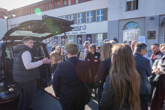 Uczestnicy oglądają wystawę samochodów dostosowanych, zaprezentowanych przez Firmę "Kamuko".