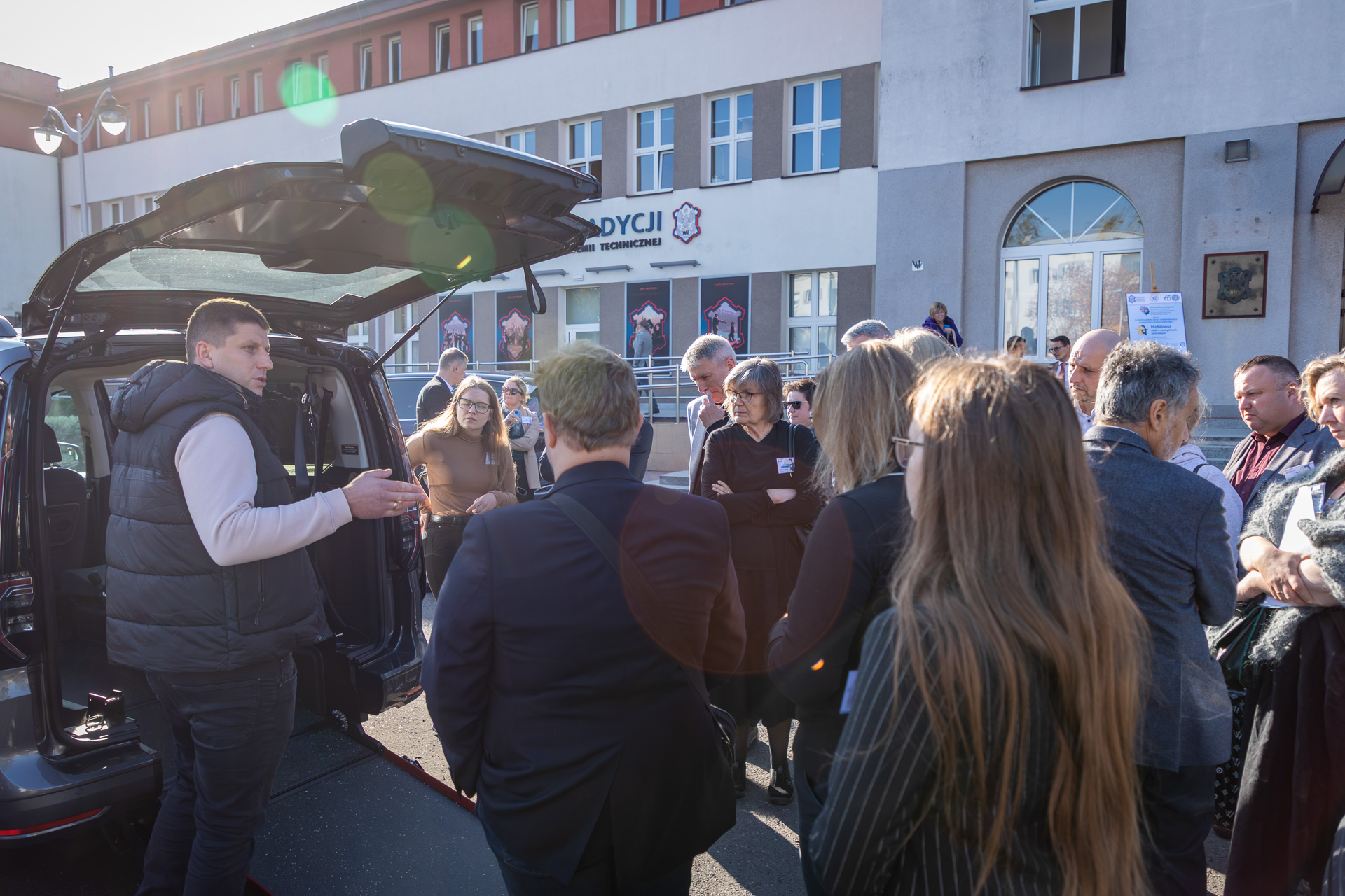 Uczestnicy oglądają wystawę samochodów dostosowanych, zaprezentowanych przez Firmę "Kamuko".
