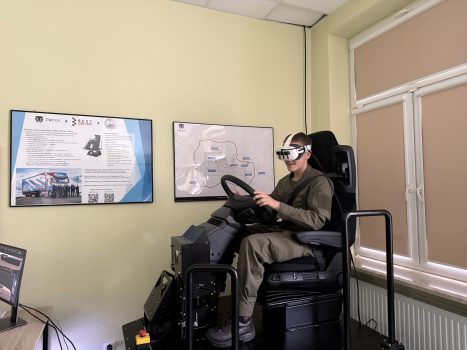 Prezentacja symulatora VR jazdy samochodem ciężarowym - w symulatorze siedzi jeden z uczniów.