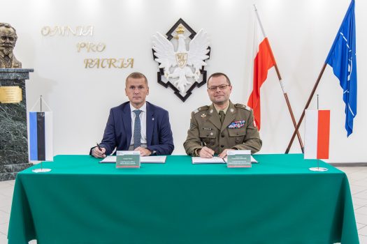 Zdjęcie przedstawia moment podpisania porozumienia o współpracy pomiędzy Wojskową Akademią Techniczną a firmą Milrem Robotics praz Rektora-Komendanta WAT gen. bryg. prof. dr hab. inż. Przemysław Wachulak oraz Prezesa Milrem Robotics - Kuldara Väärsi.