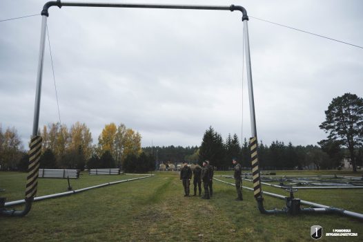 Podchorąży stoją pod przejściem bramowym.