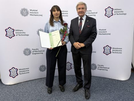 Dziekan wraz ze studentką trzymającą wyróżnienie, w tle ścianka z logami WAT i WIM