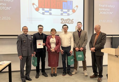Na tle baneru ROBOTON stoją: sekretarz komisji konkursowej, prodziekan ds. nauki Wydziału Inżynierii Mechanicznej, trzej studenci – laureaci nagrody Dziekana WIM – oraz Dyrektor IRiKM WIM WAT. Studenci trzymają dyplomy i zielone torby prezentowe.