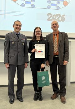 Na tle baneru ROBOTON stoją: sekretarz komisji konkursowej, Dyrektor IRiKM WIM WAT oraz studentka wyróżniona w konkursie, trzymająca dyplom i zieloną torbę prezentową.