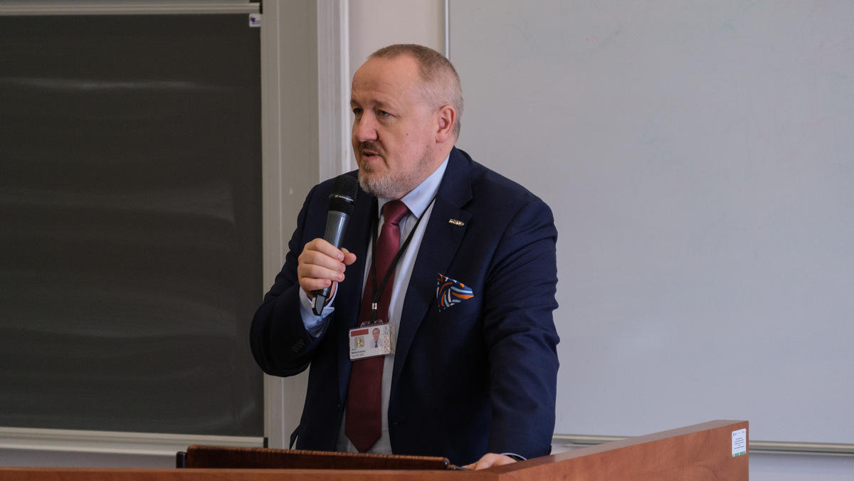 Dziekan WIM witający uczestników seminarium, przemawia stojąc przodem do gości zgromadzonych na sali.