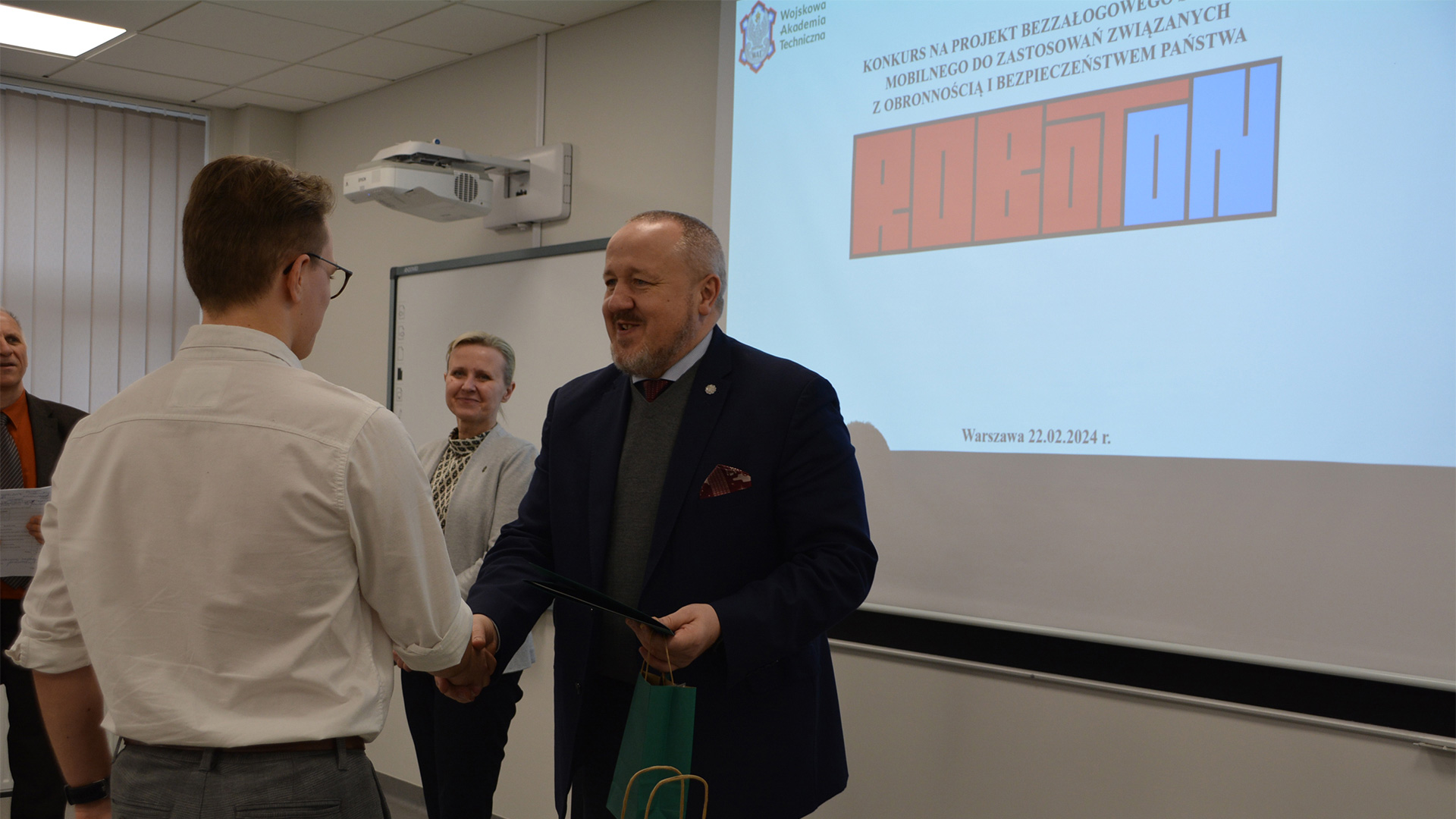 Fot. 3. Wręczenie nagród uczestnikom konkursu ROBOTON - dziekan WIM ściska dłoń laureatowi.