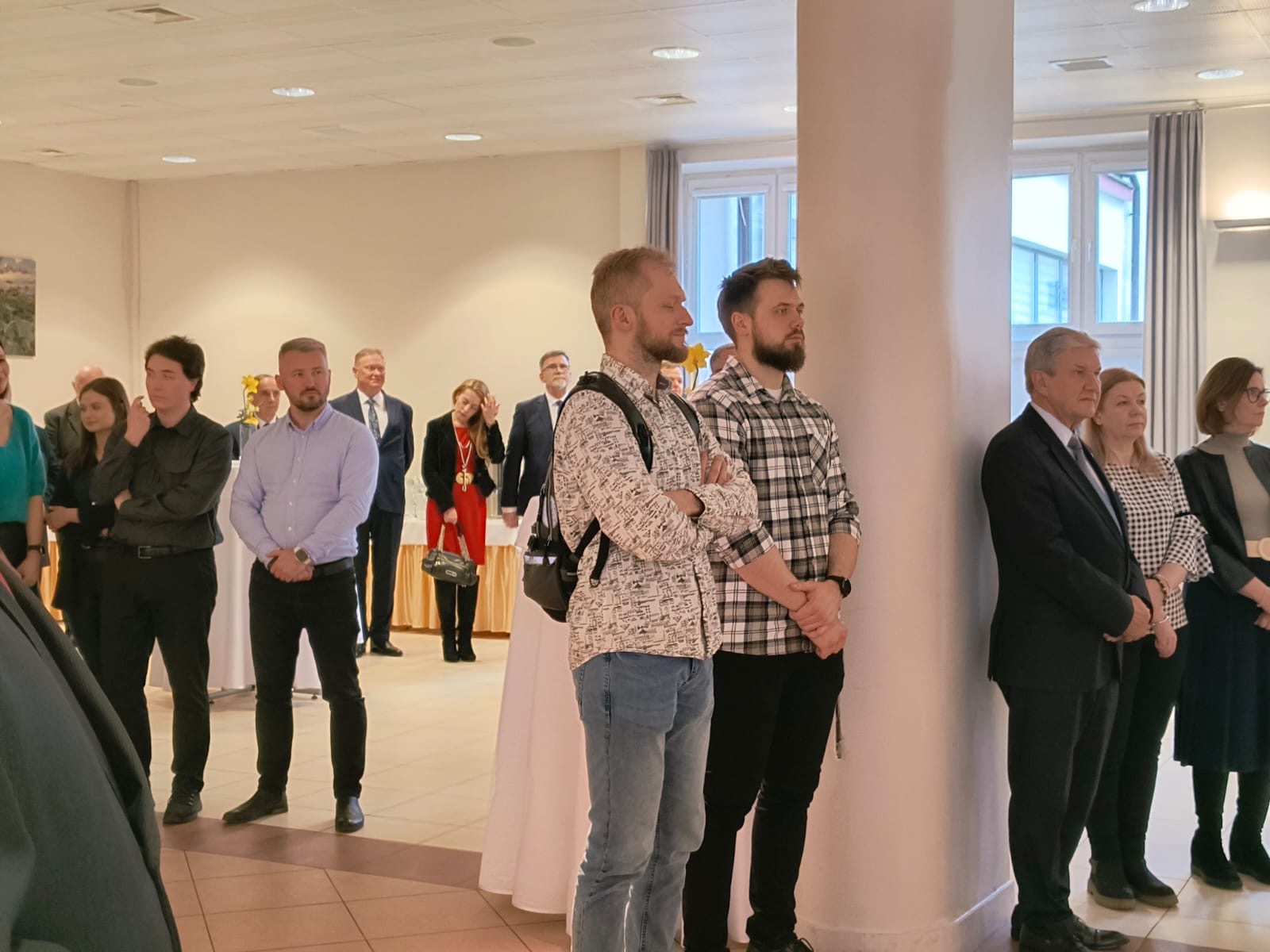 Fot. 3. Na sali stoją zgromadzeni gości, pracownicy WIM.