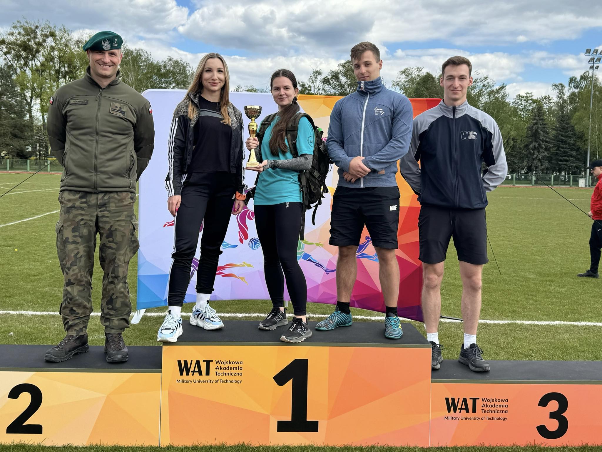 Reprezentanci - sportowcy WIM stoją na wszystkich szczebach podpim pozując do pamiątkowego zdjęcia.