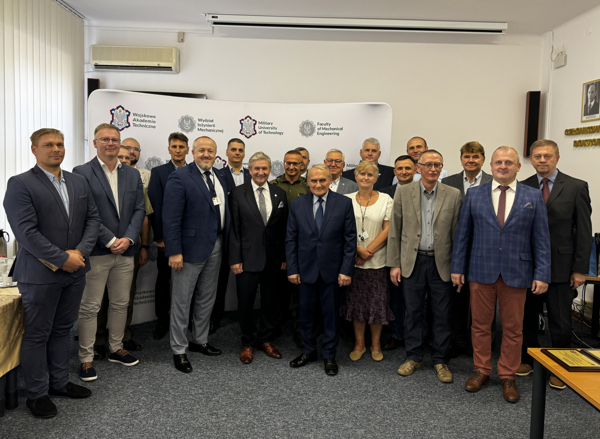 Grupa osób stojących przodem do zdjęcia, w sali rady dyscypliny, w tle baner WIM WAT.