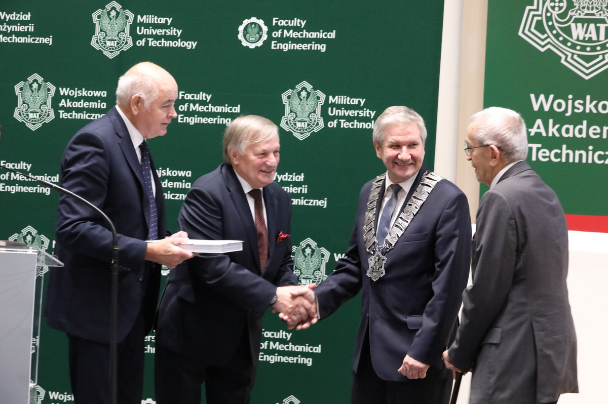 Tyłem do sceny, przodem do zgromadzonych stoją wyróżniony Dziekan z osobami wręczającymi dyplom.