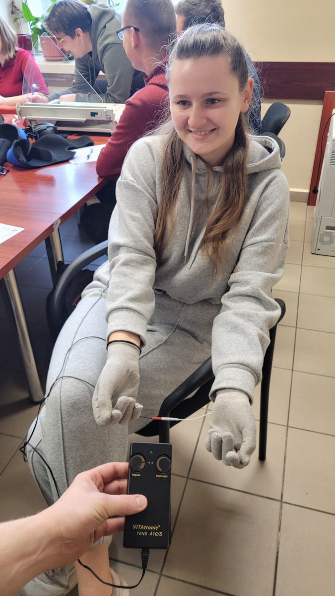 7. Studentka z założonymi na dłonie symulatorami drżenia rąk.