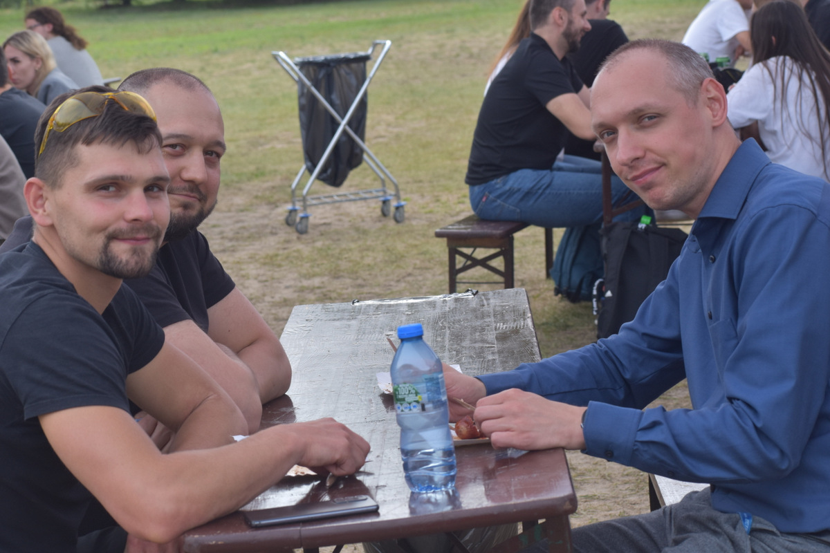 Piknik WIM i WML - na zdjęciu osoby stoją na polanie, na trawie, w tle namioty z napisami WAT.